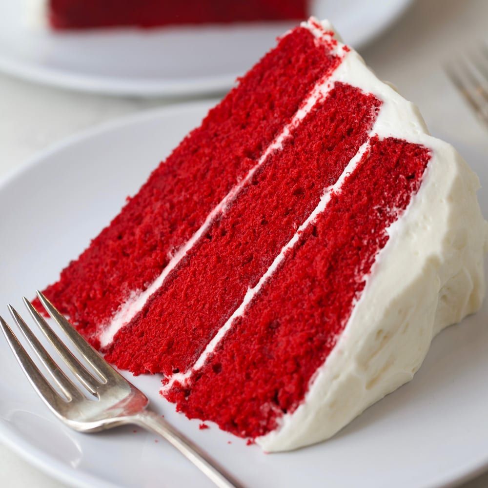Sliced red velvet layer cake showing moist crumb and cream cheese frosting between layers